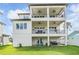 Elegant three-story home featuring multiple balconies and a well-manicured lawn perfect for outdoor living at 16025 Redington Dr, Redington Beach, FL 33708