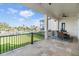 Covered patio features waterfront views, a table with chairs, and black metal railings at 16025 Redington Dr, Redington Beach, FL 33708