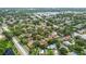 Aerial view of neighborhood showcasing community pond and mature landscaping throughout the area at 1693 Fry Ct, Dunedin, FL 34698