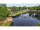 Aerial view of the community pond with a wooden deck, lush surroundings, and a water fountain feature at 1693 Fry Ct, Dunedin, FL 34698