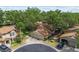 Aerial view of a well-maintained home with a three-car garage, lush landscaping, and mature trees at 1693 Fry Ct, Dunedin, FL 34698