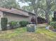 The side of the house with landscaping, utilities, and mature trees at 1693 Fry Ct, Dunedin, FL 34698