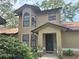 Inviting home exterior featuring neutral stucco, decorative plants, and an eye-catching arched window at 1693 Fry Ct, Dunedin, FL 34698