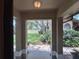 Covered front porch view showing well-manicured lawn, walkway, and mature trees at 1693 Fry Ct, Dunedin, FL 34698