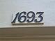 A close-up of the house number 1693 on a light textured wall near the front door at 1693 Fry Ct, Dunedin, FL 34698