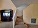 Inviting living room view with carpeted stairs, a TV, and a modern entertainment center at 1693 Fry Ct, Dunedin, FL 34698