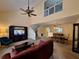Open-concept living and dining area with soaring ceilings, fan, and large windows at 1693 Fry Ct, Dunedin, FL 34698