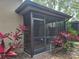A screened porch surrounded by tropical plants creates a private outdoor living space at 1693 Fry Ct, Dunedin, FL 34698