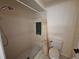 Clean shower area with tiled walls, handheld shower head, and a convenient toilet at 1693 Fry Ct, Dunedin, FL 34698