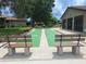 Charming shuffleboard court with shaded benches and landscaping perfect for outdoor recreation at 1693 Fry Ct, Dunedin, FL 34698