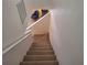 Carpeted staircase leading to a cozy landing with blue chair at 1693 Fry Ct, Dunedin, FL 34698