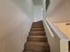 Carpeted stairs with white railing lead to the upper level of the house at 1693 Fry Ct, Dunedin, FL 34698