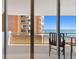 Inviting outdoor balcony featuring a set of patio furniture with an ocean view and building in the background at 17920 Gulf Blvd # 1302, Redington Shores, FL 33708