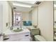 Cozy bathroom with a vanity, mirror, tiled countertops, fixtures, and a view into an adjacent hallway at 17920 Gulf Blvd # 1302, Redington Shores, FL 33708