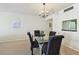 A dining room features a glass table with seating for four, illuminated by a decorative chandelier at 17920 Gulf Blvd # 1302, Redington Shores, FL 33708