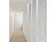 Hallway featuring closet doors, neutral carpet, and doorway to a room with natural light at 17920 Gulf Blvd # 1302, Redington Shores, FL 33708