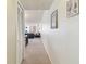 Bright hallway leading to living area, featuring neutral walls and carpeting, with art decorations and natural light at 17920 Gulf Blvd # 1302, Redington Shores, FL 33708