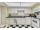 Well-lit kitchen with black and white checkered floors, white cabinets, and modern appliances at 17920 Gulf Blvd # 1302, Redington Shores, FL 33708