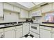 Bright kitchen with checkered floors, white appliances, and efficient counter space at 17920 Gulf Blvd # 1302, Redington Shores, FL 33708