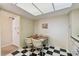 Bright kitchen nook featuring black-and-white tile flooring and a dining area with seating for four at 17920 Gulf Blvd # 1302, Redington Shores, FL 33708
