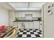 Well-lit kitchen with black and white checkered floors, white cabinets, and updated appliances at 17920 Gulf Blvd # 1302, Redington Shores, FL 33708