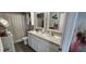Bathroom includes a double vanity, framed mirrors, a toilet, and a shower with curtain at 1853 Hovenweep Rd, Wesley Chapel, FL 33543