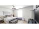 Bright bedroom with a ceiling fan, window, comfortable bed, and stylish furnishings at 1853 Hovenweep Rd, Wesley Chapel, FL 33543