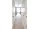 This bright hallway leads to several bedrooms or office spaces, carpeted and well-lit at 1853 Hovenweep Rd, Wesley Chapel, FL 33543