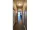 Hallway with tile flooring leading to an open dining area and sliding doors at 1853 Hovenweep Rd, Wesley Chapel, FL 33543