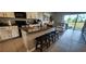 Contemporary kitchen with granite counters, a breakfast bar, and an open view to the living area and patio at 1853 Hovenweep Rd, Wesley Chapel, FL 33543