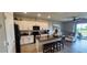 Open-concept kitchen flowing into a living area, featuring white cabinets and a center island at 1853 Hovenweep Rd, Wesley Chapel, FL 33543