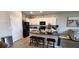 Modern kitchen with white cabinets, black appliances, and a granite-topped island with bar stool seating at 1853 Hovenweep Rd, Wesley Chapel, FL 33543