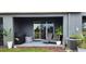 Inviting outdoor patio area with sliding glass doors, modern furniture, and grill, perfect for relaxation at 1853 Hovenweep Rd, Wesley Chapel, FL 33543