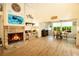Open living space with a stone fireplace, laminate flooring, and a view of the dining area, creating a cozy atmosphere at 2101 Sunset Point Rd # 1806, Clearwater, FL 33765