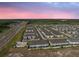 An aerial view of a townhome community with a pool, green spaces, and meticulously manicured lawns at 2529 Arbor Wind Dr, Lutz, FL 33558