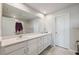 Bathroom with double sinks, white cabinetry, large mirror, and tile flooring at 2529 Arbor Wind Dr, Lutz, FL 33558