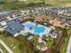 Aerial view of a community pool and playground, surrounded by lush greenery and well-maintained homes in the neighborhood at 2529 Arbor Wind Dr, Lutz, FL 33558