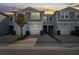Charming townhome with gray siding, a one-car garage, and a well-maintained paver driveway under a sunset sky at 2529 Arbor Wind Dr, Lutz, FL 33558
