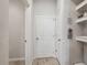 Clean and bright hallway featuring neutral paint, decorative wall art, and a mix of closet and doorway openings at 2529 Arbor Wind Dr, Lutz, FL 33558