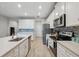 Modern kitchen with white cabinets, stainless steel appliances, and a stylish blue tiled backsplash at 2529 Arbor Wind Dr, Lutz, FL 33558