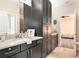 Bathroom with a double vanity, dark cabinets, and a doorway to a bedroom at 2608 Calvano Dr, Land O Lakes, FL 34639