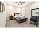 Cozy bedroom with hardwood floors, ceiling fan, and a large window at 2608 Calvano Dr, Land O Lakes, FL 34639