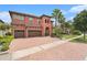 Mediterranean-style home featuring a brick driveway, two-car garage, and well-manicured landscaping at 2608 Calvano Dr, Land O Lakes, FL 34639