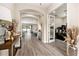 Bright and airy foyer with wood floors, arched doorways, and access to a home office and living spaces at 2608 Calvano Dr, Land O Lakes, FL 34639