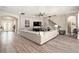 Bright living room with wood floors, a large sectional sofa, and staircase leading to the upper level at 2608 Calvano Dr, Land O Lakes, FL 34639