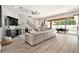 Open-concept living room featuring wood floors, a large sectional sofa, and access to the outdoor patio at 2608 Calvano Dr, Land O Lakes, FL 34639