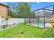 Relaxing screened-in pool with lush green landscaping, and white fence offering privacy at 2608 Calvano Dr, Land O Lakes, FL 34639