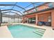 Covered outdoor space features beautiful pool with integrated spa and ample seating at 2608 Calvano Dr, Land O Lakes, FL 34639