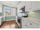 Bright kitchen features stainless steel appliances, white cabinets and subway tile backsplash at 2628 2Nd N Ave, St Petersburg, FL 33713