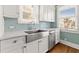 Bright kitchen with stainless steel appliances, white cabinets, and farm sink below two windows at 2628 2Nd N Ave, St Petersburg, FL 33713